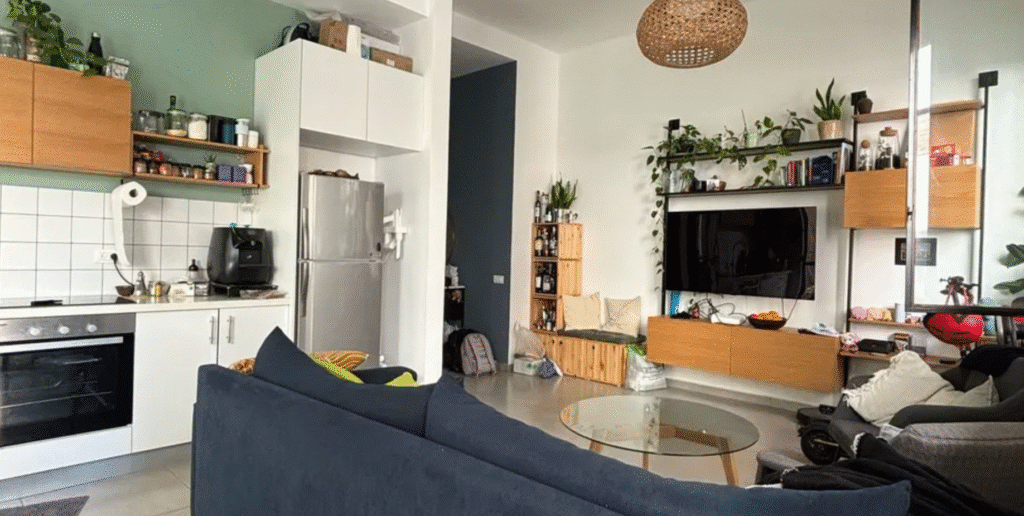 Cozy living space with TV and built-in shelving in Tel Aviv apartment