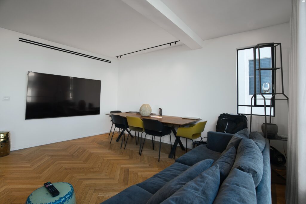 Dining area with TV and wood flooring in Tel Aviv apartment