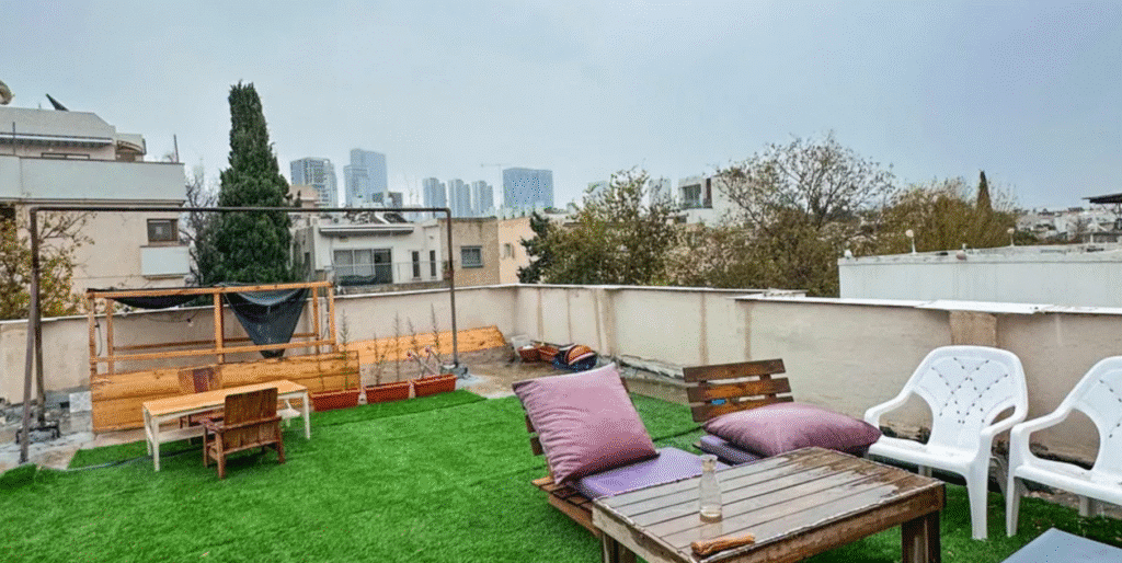 Rooftop with artificial grass, lounge furniture, and Tel Aviv skyline