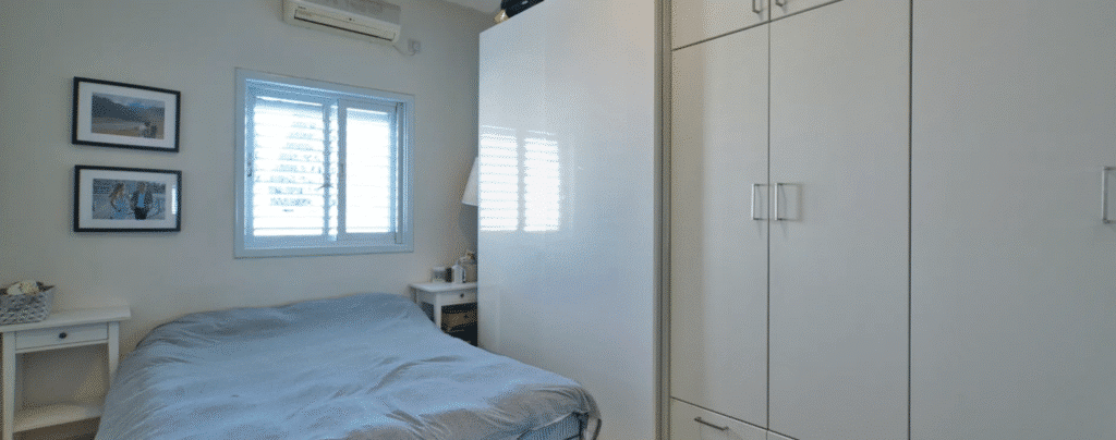 Cozy bedroom with built-in closets in renovated North Tel Aviv apartment