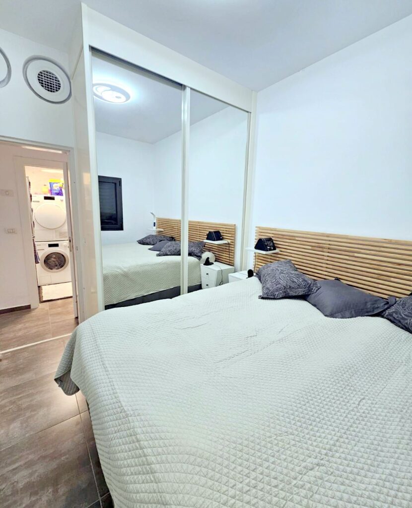 Bright bedroom with mirrored closet in Tel Aviv apartment