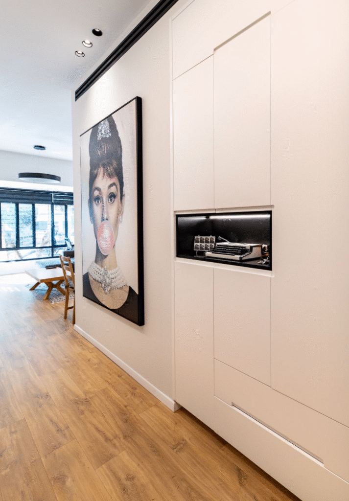Hallway with stylish artwork and built-in storage in Tel Aviv apartment
