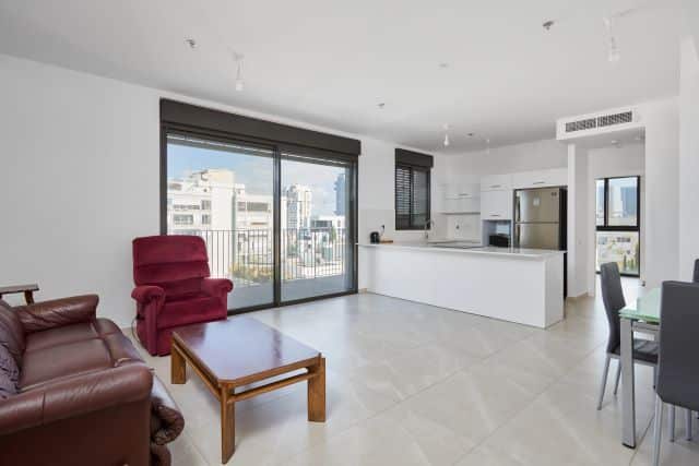Open living and kitchen area with city-facing balcony