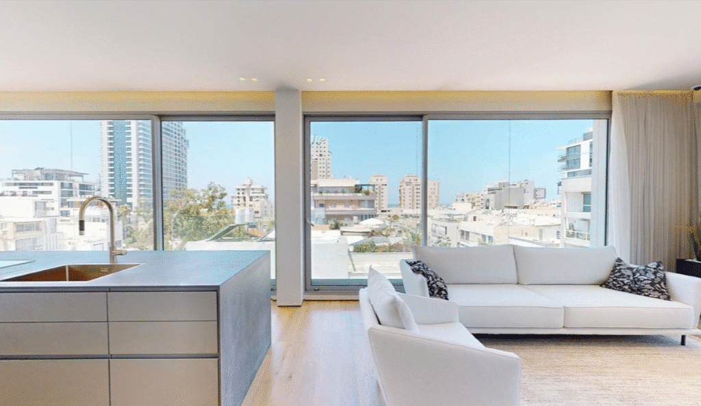 White sofa set in bright living room overlooking Tel Aviv skyline