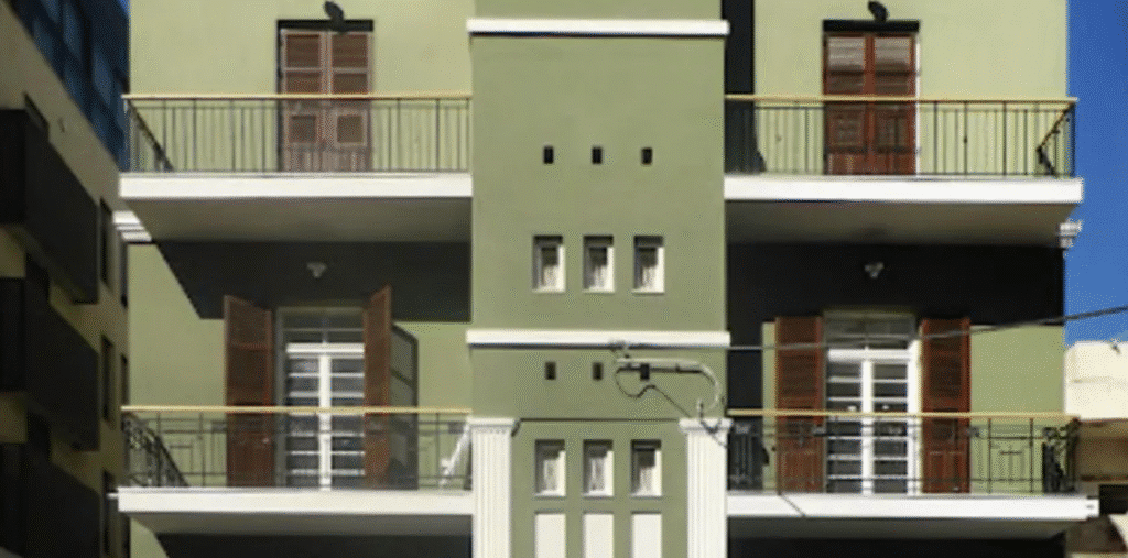 Preserved Tel Aviv building with green facade and balconies