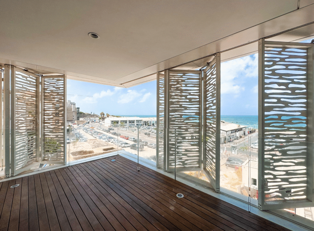 Balcony with sea view and sculptural shutters overlooking Tel Aviv Port
