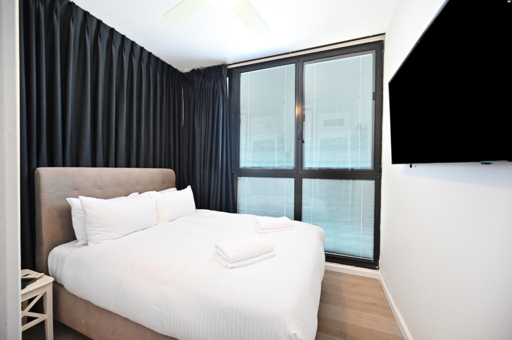 Bright designer bedroom with TV in Tel Aviv furnished penthouse