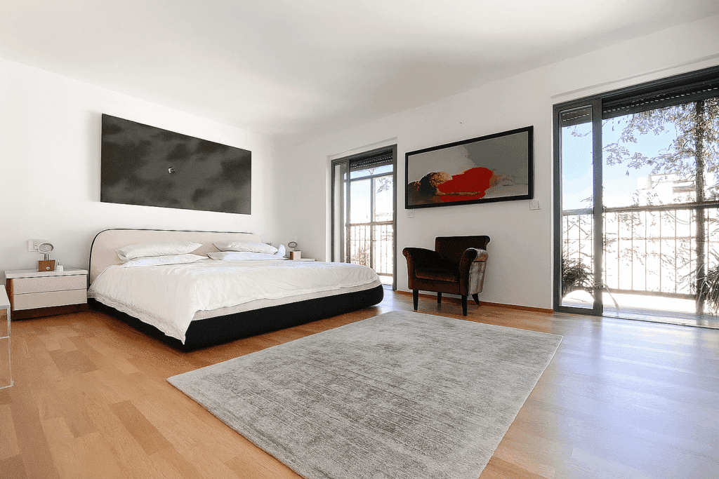 Bright and minimalist master bedroom with balcony access in Rothschild area penthouse