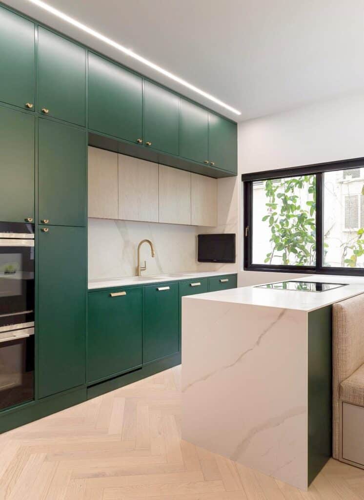 Modern kitchen island and bright window in renovated Tel Aviv apartment