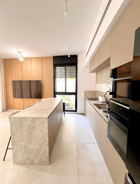 Modern kitchen with island in luxury apartment near Kikar Hamedina