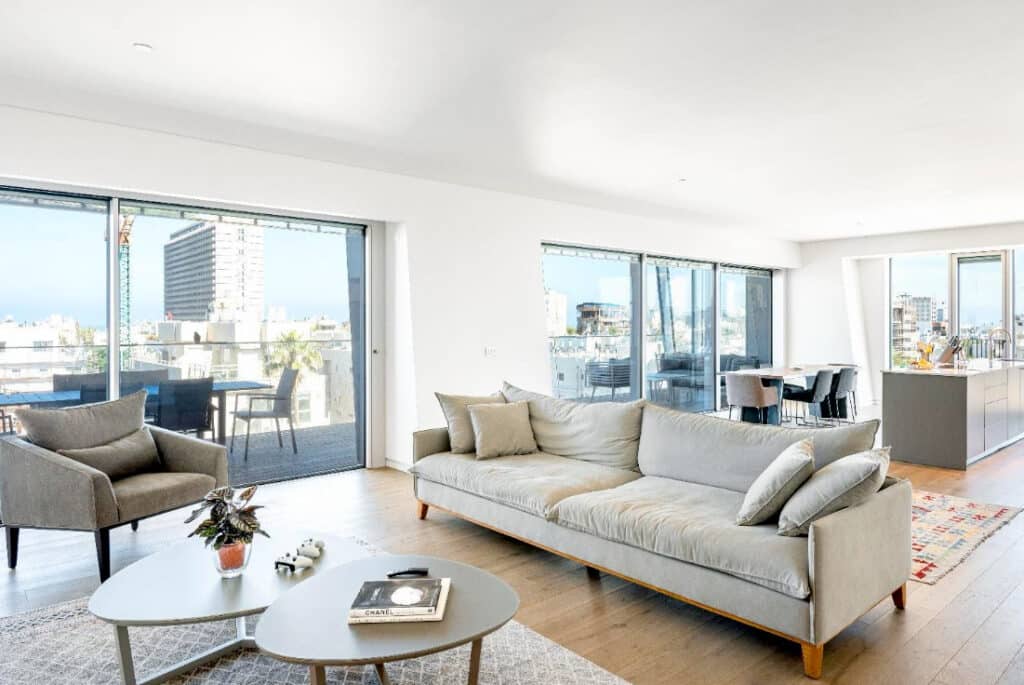 Elegant living room with large sofa and access to sea-view balcony Elegant living room with large sofa and access to sea-view balcony