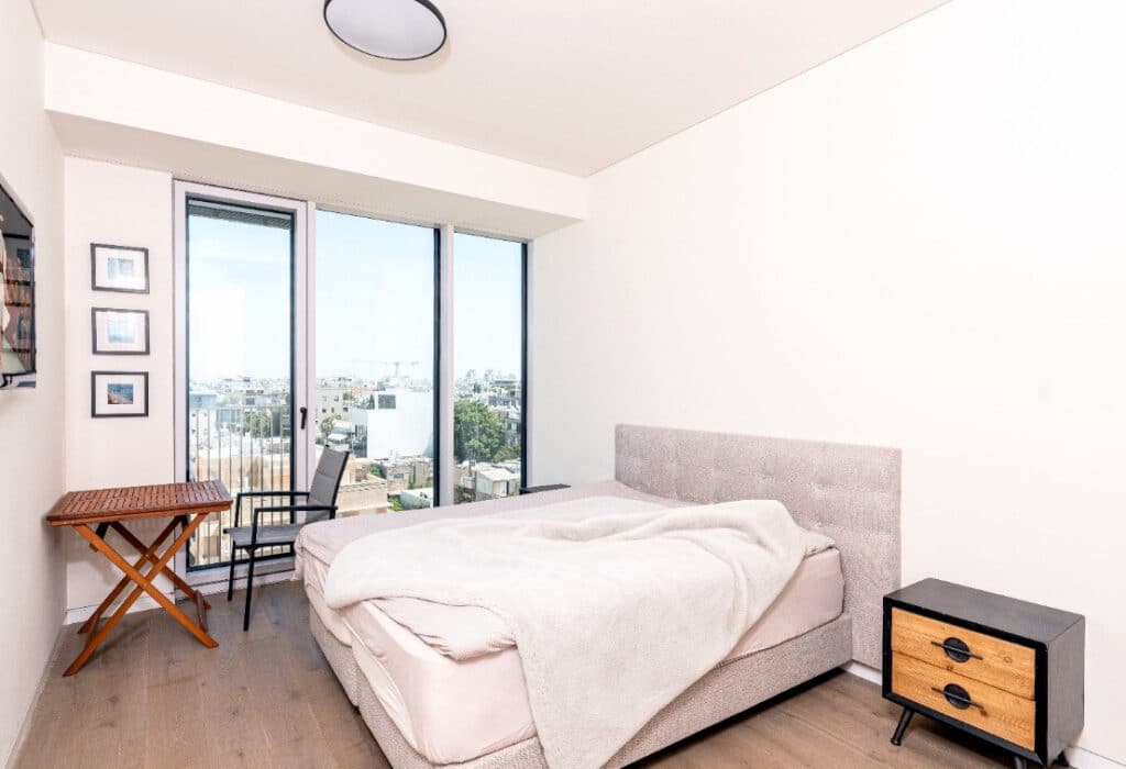 Bright and modern master bedroom with city views in Arlozorov 17 Tower apartment